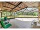 Relaxing screened-in patio with tile flooring and a view of the expansive backyard, perfect for outdoor living at 6702 Towhe Dr, Seffner, FL 33584