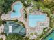 Overhead shot of swimming pools and community center surrounded by lush landscaping and mature trees at 7815 Blue Spring Dr, Land O Lakes, FL 34637