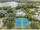 Aerial view of tennis courts, pools, and a community center amidst lush landscaping at 7815 Blue Spring Dr, Land O Lakes, FL 34637