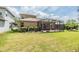 Expansive backyard featuring a screened-in patio, lush lawn and mature landscaping at 7815 Blue Spring Dr, Land O Lakes, FL 34637