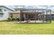 A backyard featuring a screened-in patio with brick flooring and a lush green lawn at 7815 Blue Spring Dr, Land O Lakes, FL 34637