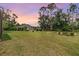 Expansive backyard with lush lawn, landscape lighting, and mature trees, perfect for outdoor entertaining at 7815 Blue Spring Dr, Land O Lakes, FL 34637