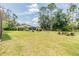 Expansive backyard featuring a well-maintained lawn, landscaping, and screened-in porch perfect for outdoor enjoyment at 7815 Blue Spring Dr, Land O Lakes, FL 34637