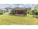 A backyard featuring a screened-in patio with brick flooring and a well-maintained green lawn at 7815 Blue Spring Dr, Land O Lakes, FL 34637