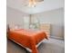 Cozy bedroom featuring carpet, bright colored bedspread, and natural light from the window at 7815 Blue Spring Dr, Land O Lakes, FL 34637