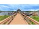 Long wooden dock with a covered gazebo offering scenic lake views and boat access at 7815 Blue Spring Dr, Land O Lakes, FL 34637