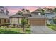 Charming home featuring a well-manicured lawn, two-car garage, and delightful landscaping at 7815 Blue Spring Dr, Land O Lakes, FL 34637