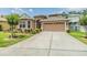 Two-story home featuring a paved driveway, two-car garage, and well-manicured front yard at 7815 Blue Spring Dr, Land O Lakes, FL 34637