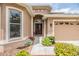 Charming home exterior featuring a well-manicured lawn, colorful flowers, and a private two-car garage at 7815 Blue Spring Dr, Land O Lakes, FL 34637