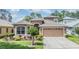 Charming home featuring a manicured lawn, fresh landscaping, and a paved driveway at 7815 Blue Spring Dr, Land O Lakes, FL 34637