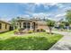 Charming front yard with a lush lawn, mature landscaping, and a paved driveway at 7815 Blue Spring Dr, Land O Lakes, FL 34637