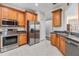 Bright kitchen features stainless steel appliances, wooden cabinetry, and tile flooring at 7815 Blue Spring Dr, Land O Lakes, FL 34637