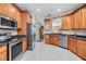 Modern kitchen equipped with stainless steel appliances and wooden cabinets with dark countertops at 7815 Blue Spring Dr, Land O Lakes, FL 34637
