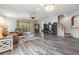 Open-concept living room showcasing hardwood floors, neutral walls, and a seamless transition to the stairwell at 7815 Blue Spring Dr, Land O Lakes, FL 34637