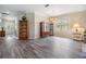 Spacious living room featuring hardwood floors, a chandelier, and a large window that provides ample natural light at 7815 Blue Spring Dr, Land O Lakes, FL 34637