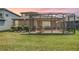 Relaxing screened patio with a BBQ, outdoor seating, and a spacious lawn at 7815 Blue Spring Dr, Land O Lakes, FL 34637