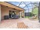 Inviting screened patio with brick flooring, outdoor seating, and lush greenery view at 7815 Blue Spring Dr, Land O Lakes, FL 34637