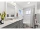 Bright bathroom with updated vanity, tub, and shower featuring elegant marble-style tiling at 914 Woodland Dr, Palm Harbor, FL 34683