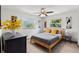 Comfortable bedroom with gray walls, a wood bed frame, large windows, and unique art pieces at 914 Woodland Dr, Palm Harbor, FL 34683