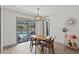 Bright dining area with modern table and chairs, offering a view of the screened-in pool area at 914 Woodland Dr, Palm Harbor, FL 34683