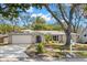 Charming single-story home with a well-manicured lawn, lush trees, and a freshly painted two car garage at 914 Woodland Dr, Palm Harbor, FL 34683