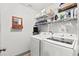 Laundry room with white washer and dryer, plus wire racks for easy storage at 914 Woodland Dr, Palm Harbor, FL 34683
