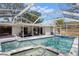 Backyard view of a beautiful in-ground pool with a jacuzzi and covered patio area at 914 Woodland Dr, Palm Harbor, FL 34683