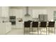 Bright kitchen features white cabinets, modern stainless steel appliances, and a large island with barstool seating at 9384 Gladsome Dr, Land O Lakes, FL 34637