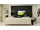 Cozy living room featuring a plush sofa, modern décor, a dark accent wall with wall mounted television at 9384 Gladsome Dr, Land O Lakes, FL 34637