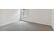 Minimalist bedroom featuring plush gray carpeting and a large window for natural light at 9766 Crescent Moon Dr, Riverview, FL 33578