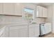 Well-appointed kitchen featuring white cabinetry, stainless steel dishwasher, and quartz countertops with tile backsplash at 9766 Crescent Moon Dr, Riverview, FL 33578