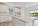Bright kitchen with white cabinets, stainless steel appliances, quartz countertops and a large center island at 9766 Crescent Moon Dr, Riverview, FL 33578