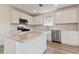 Modern kitchen featuring white cabinets, stainless steel appliances, and a center island with quartz countertops at 9766 Crescent Moon Dr, Riverview, FL 33578