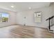 Spacious living room with wood-look flooring, lots of natural light, and staircase at 9766 Crescent Moon Dr, Riverview, FL 33578