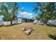 A large backyard shows mature trees, a patio, and a well maintained lawn and exterior in a natural setting at 10115 Kenlake Dr, Riverview, FL 33578