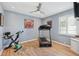 This exercise room features wood floors, blue walls, a ceiling fan, and an exercise bike and treadmill at 10115 Kenlake Dr, Riverview, FL 33578
