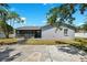 The home's exterior shows a large backyard, mature trees, a screened patio and a neutral color scheme at 10115 Kenlake Dr, Riverview, FL 33578