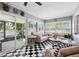 This Florida room is decorated with a black and white checkered floor and stylish seating perfect for entertaining at 10115 Kenlake Dr, Riverview, FL 33578
