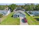 Aerial view of a well-maintained home with a large lawn and a driveway with a parked vehicle at 10463 Baylor Dr, Spring Hill, FL 34608