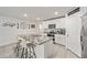 Kitchen island with granite countertops, white cabinetry, and barstool seating overlooking the kitchen at 10463 Baylor Dr, Spring Hill, FL 34608
