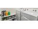 Bright laundry room featuring white washer and dryer, and organized storage shelves at 10463 Baylor Dr, Spring Hill, FL 34608