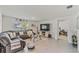 Comfortable living room with a gray sectional, tile floors, and an open doorway to another room at 10463 Baylor Dr, Spring Hill, FL 34608