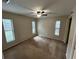 Bedroom with tan carpet, multiple windows providing natural light, and a ceiling fan at 1309 Malone Ave, Spring Hill, FL 34606