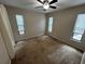 Bedroom featuring a ceiling fan, multiple windows, and wall-to-wall carpet at 1309 Malone Ave, Spring Hill, FL 34606