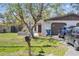 Exterior of home with a large tree and parked cars at 1309 Malone Ave, Spring Hill, FL 34606