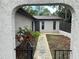 Charming facade featuring an arched entryway that leads to the front door, with fresh mulch and green grass at 1309 Malone Ave, Spring Hill, FL 34606