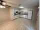 Bright eat-in kitchen featuring tile floors, white cabinets, white appliances, and ample countertop space at 1309 Malone Ave, Spring Hill, FL 34606