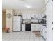 Bright kitchen featuring white appliances, cabinets, and tile flooring at 1309 Malone Ave, Spring Hill, FL 34606
