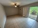 Living room featuring tile floors, a ceiling fan with lighting, and a glass sliding door at 1309 Malone Ave, Spring Hill, FL 34606