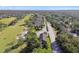 Aerial view showcases a home with a golf course, tree lined streets, and surrounding neighborhood at 1341 Marinella Dr, Palm Harbor, FL 34683